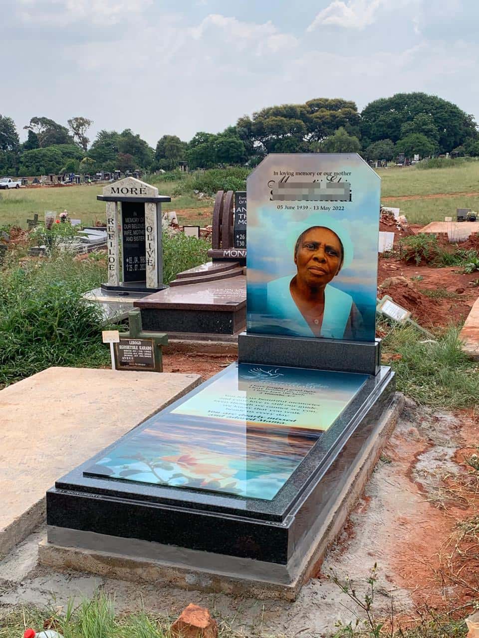 Glass memorial installed at a cemetery, catching the sunlight